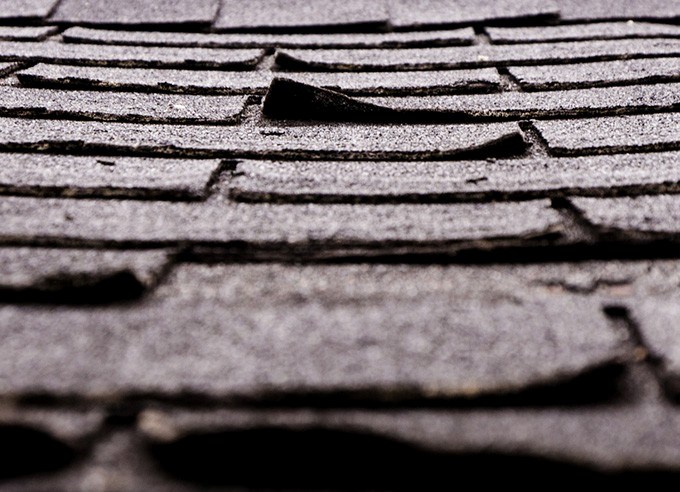 checking shingles during a roof inspection in Westwood